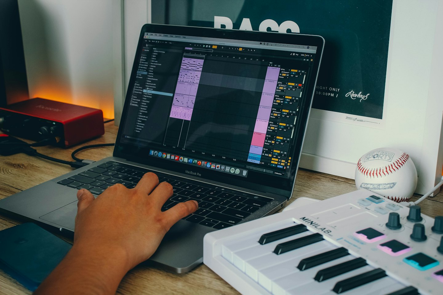 Editando música en una laptop sobre un escritorio de madera.